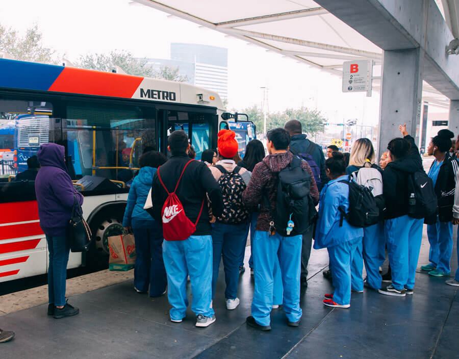 Customers standing in line to board a local METRO bus.