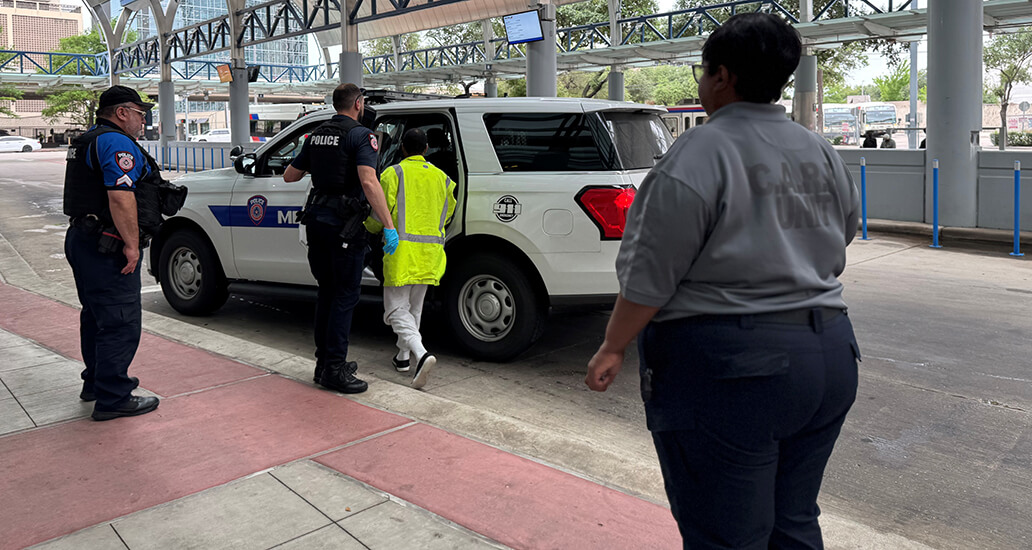 Members of the MPD C.A.R.E unit assisting an individual getting into a vehicle.